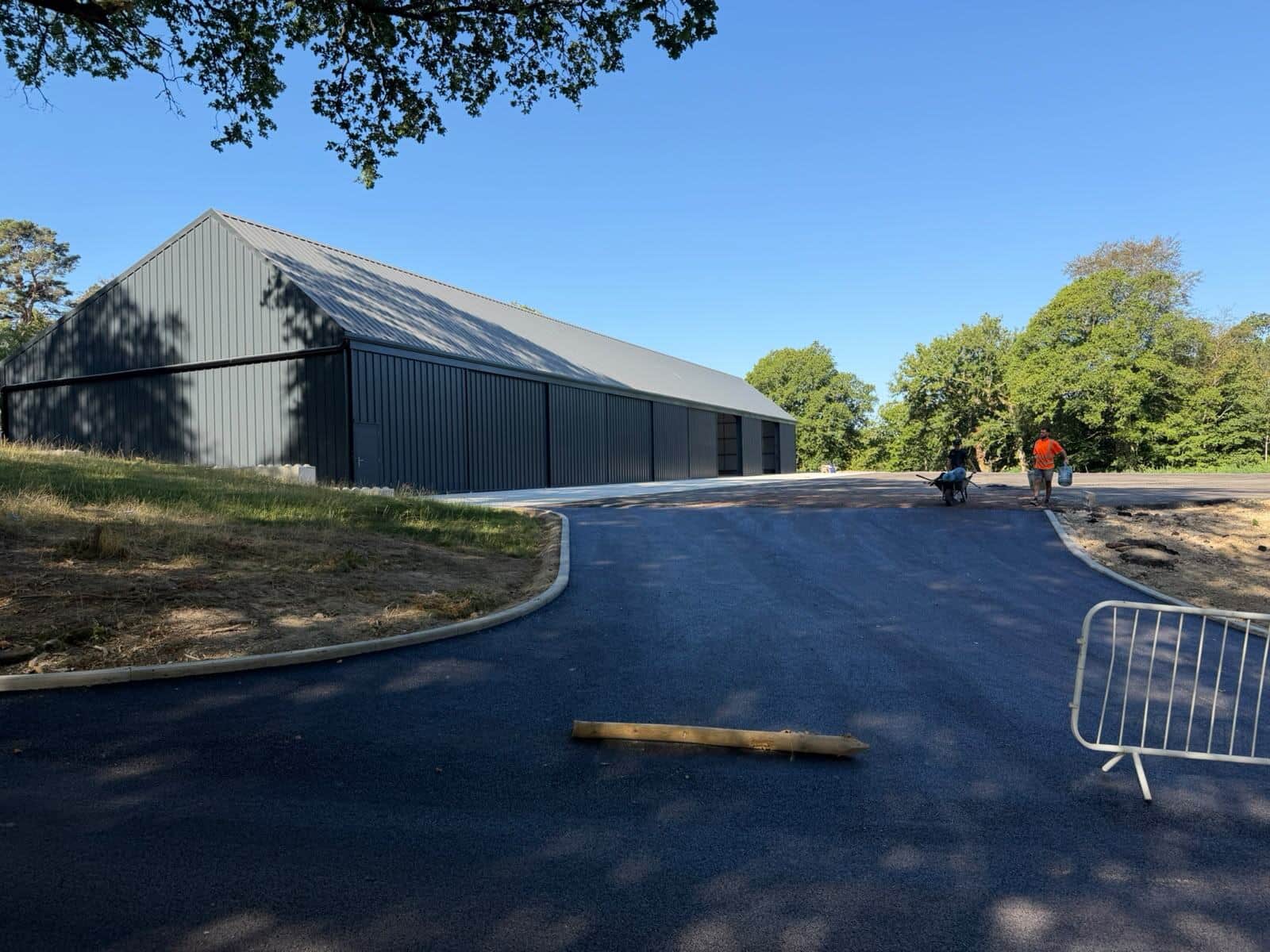 Newly surfaced bellmouth access road leading to a warehouse building